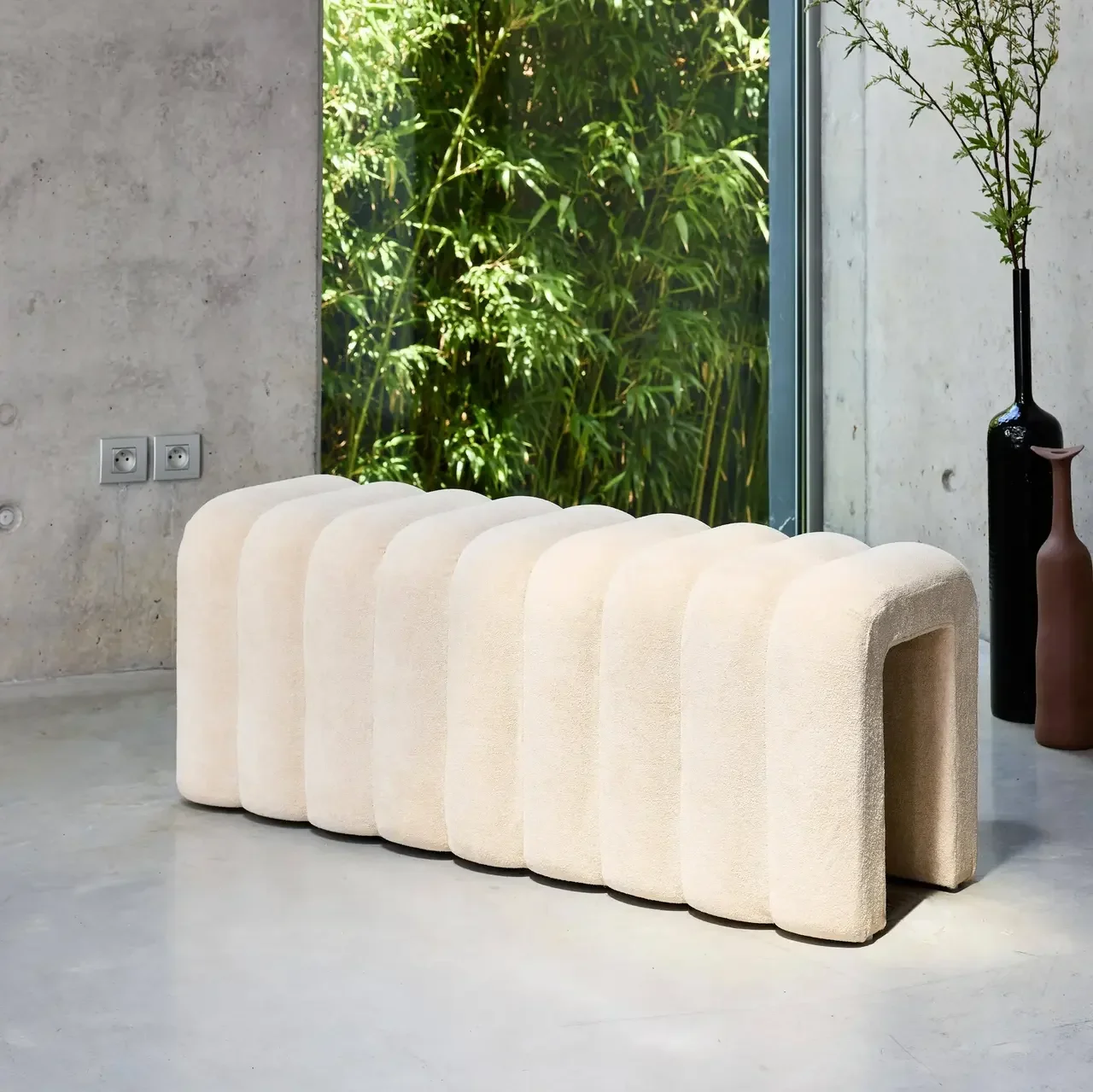 Banc de lit design contemporain en tissu gris avec courbes arrondies